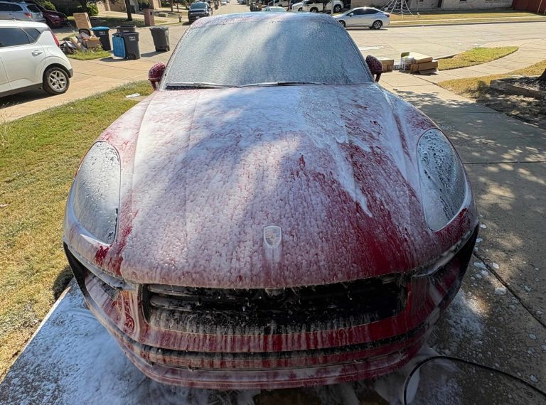 Red vehicle covered in foam during exterior wash service by Luna Car Wash & Detailing in the DFW Metroplex